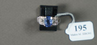 null 195- Bague en or gris sertie d'une pierre bleue épaulée de diamants baguettes...