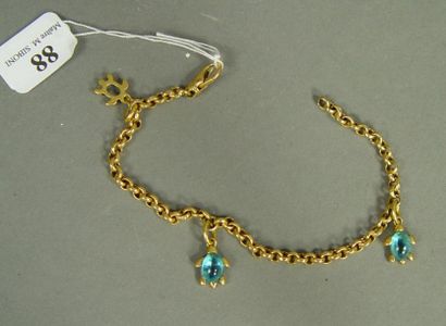 null 88- Bracelet en or jaune et ses trois breloques ''tortues'' serties de cabochons...