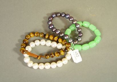 null 452- Quatre bracelets en jadéite, oeil de tigre et perles d'imitation