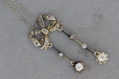 null 112- Collier négligé en or à motif de noeud serti de diamants retenant deux...