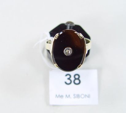 null Une bague en or jaune et onyx sertie d'un diamant central. Pds : 3,2 gr