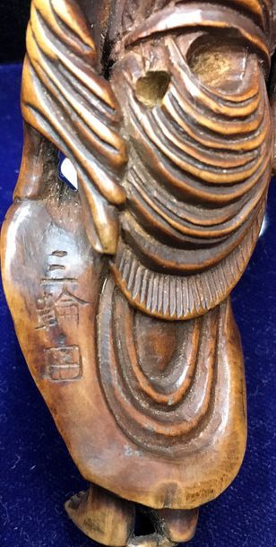 JAPON 
Grand netsuke en bois, Sennin portant un enfant dans une écharpe, tenant d'une...