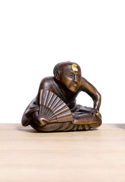 JAPON 
*Netsuke en bois, personnage assis tenant un éventail, un morceau d'ivoire...