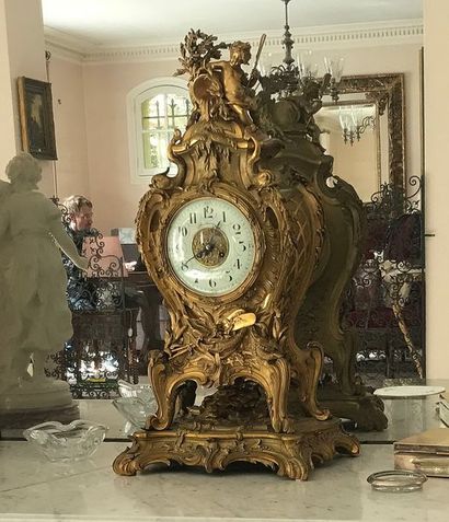 null Pendule bronze doré style Louis XV à décor d’amour, dauphins. Elle repose sur...