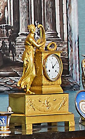 null A chased and gilded bronze clock representing an antique woman playing the harp,...