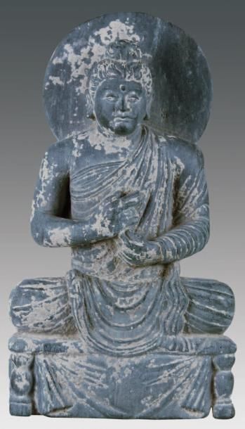 Bouddha auréolé, assis sur un trône drapé...