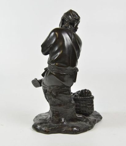 null Sujet en bronze patiné représentant un paysan assis et son panier de légumes
Japon,...