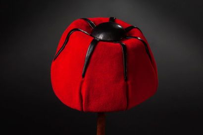 Pierre BALMAIN Chapeau toque en feutre rouge côtelé de bandes de cuir noirs surmontées...