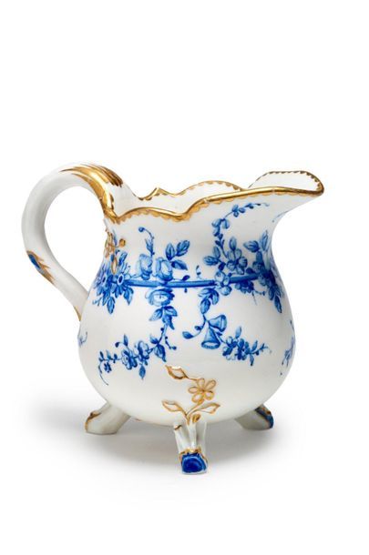 SÈVRES Pot à lait à trois pieds en porcelaine tendre, à décor en camaïeu bleu de...