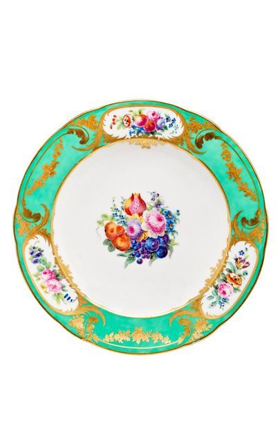 SÈVRES Assiette en porcelaine tendre, à décor polychrome de groupe de fleurs et fruits...
