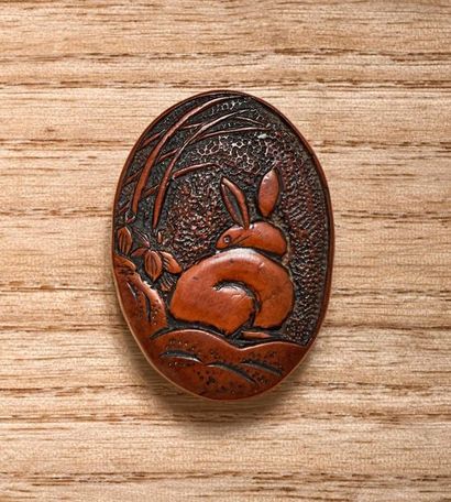 JAPON - Début XXe siècle 
Manju de forme ovale en bois, à décor d'un lapin de dos,...
