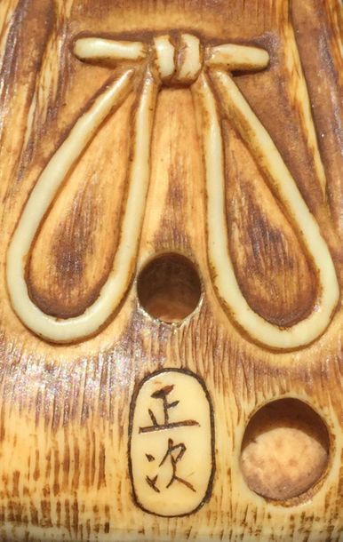 JAPON - XIXE SIÈCLE 
*Netsuke en ivoire figurant un tabako-ire fermant par un netsuke...