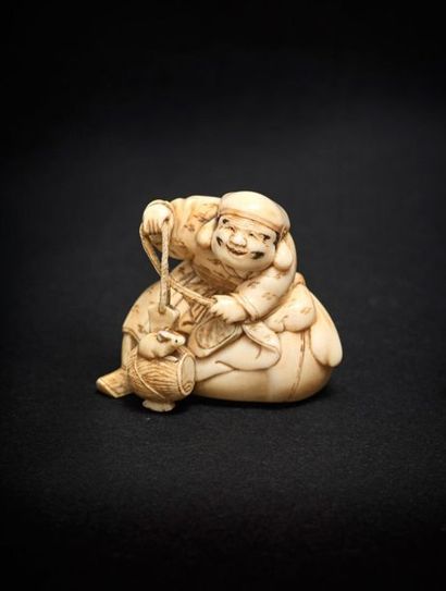 JAPON - Epoque EDO (1603 - 1868) 
*Netsuke en ivoire, Daikoku sur un grand sac, jouant...