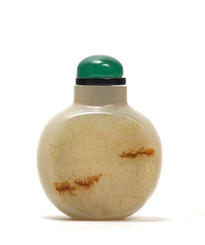 CHINE - XVIIIe siècle Round snuff bottle in clear nephrite with rust stains.
H. 4,5...