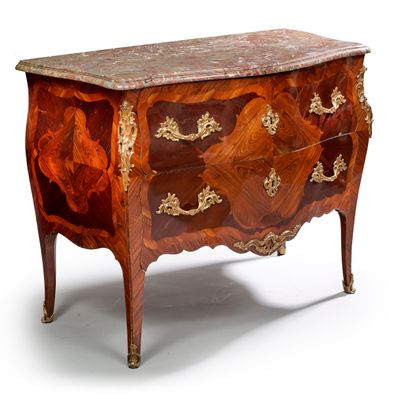 null 
A curved chest of drawers in veneer decorated with four-lobed cartouches in...