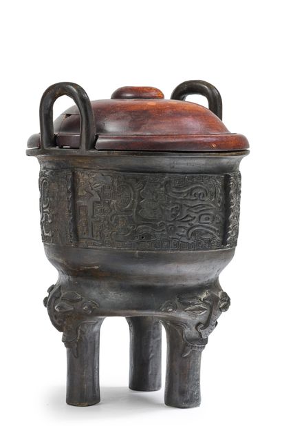 CHINE - XIXe siècle 
A tripod bronze incense burner with a brown patina and archaic...