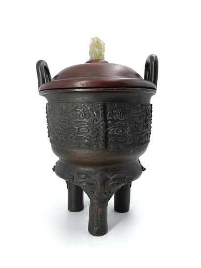 CHINE - XIXe siècle 
A tripod bronze incense burner with a brown patina and archaic...