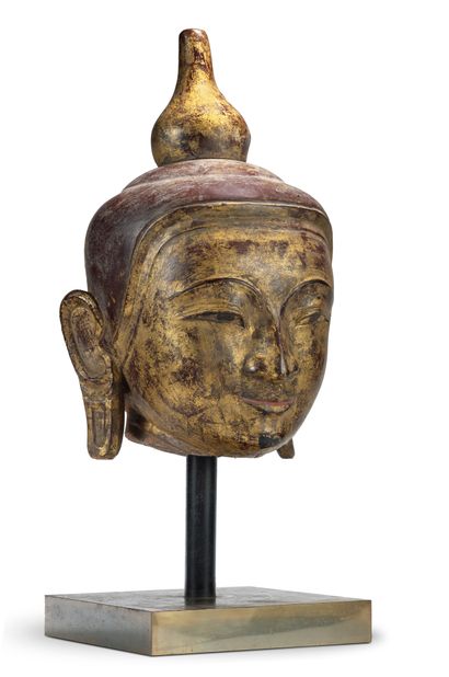 BIRMANIE - XIXe siècle Grande tête de bouddha en pierre laquée, souriant légèrement,...