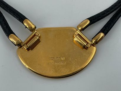 null HERMES 

Collier en cuir et métal doré et pendentif à décor émaillé d’une lyre...