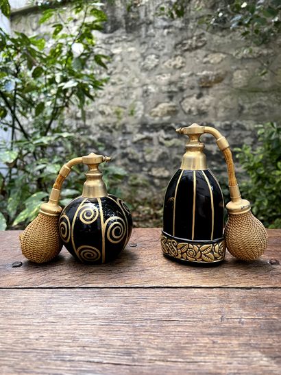 null Two perfume bottles in black tinted glass and painted with gold with floral...