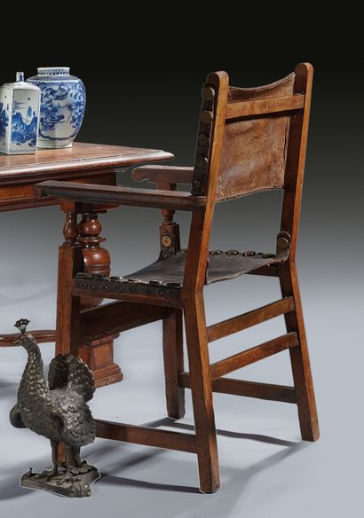 一对胡桃木扶手椅，花瓶形扶手，宽皮带，皮革软垫
西班牙，18世纪
H.110厘米...