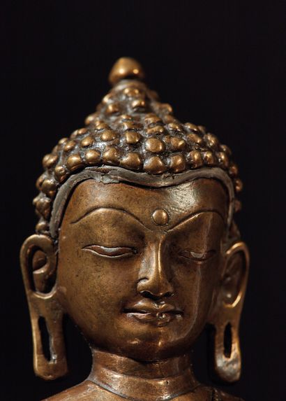 TIBET - XVIe/XVIIe siècle 释迦牟尼佛的黄铜雕像，坐在有两排莲花瓣装饰的底座上，他的双手呈bhumisparsa mudra（以大地为证...