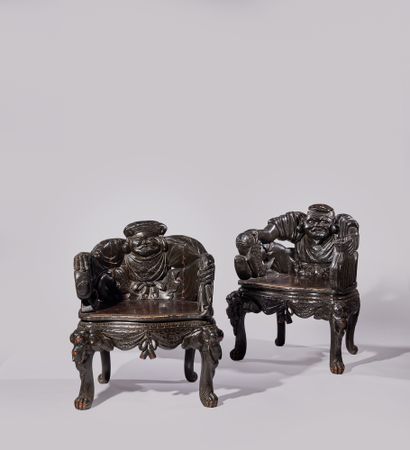 JAPON - XXe siècle Paire de fauteuils en bois sculpté noirci à décors de Daikoku...
