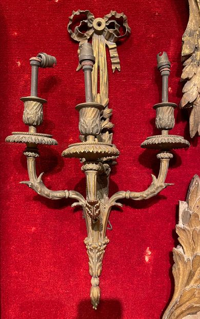 null 
一对铜质嵌花和镀金的壁灯，三条带叶子的灯臂从轴上升起，轴上有扭曲的通道，由打结的丝带固定。

路易十六风格，19世纪末

H.53厘米。
