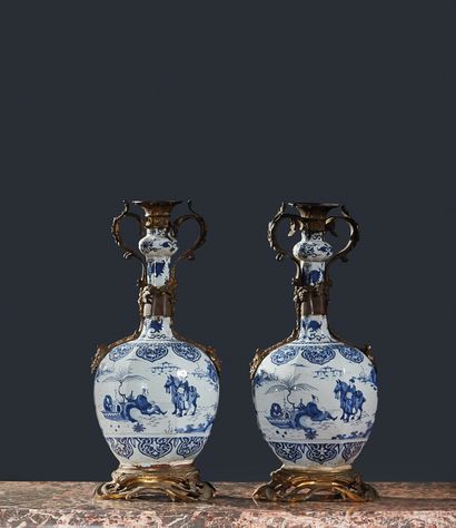 null 一对代尔夫特陶器瓶，带有中国风格的装饰，铜制支架上有棕榈、叶子和男性胡须面具的装饰。
19世纪
H.52厘米。长23厘米（事故、缺失部分和旧的修复）。