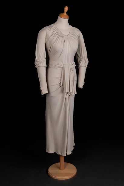 Marie-Louise BRUYÈRE 鸽灰色真丝绉绸晚礼服。褶皱的领口，后袖上有风琴管。前面收拢并在腰部打结。裙子几乎没有外翻。
大约在1930年（拉线）。