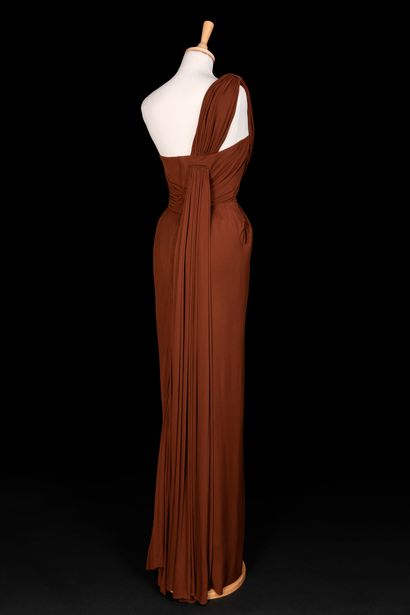 Jeanne PAQUIN 棕色丝质针织品晚装，上衣垂于单肩，落于背部的褶皱。鞘状裙，在臀部有倾斜的口袋，更加突出。
约1949年（后面的窗帘有一个小洞）。
