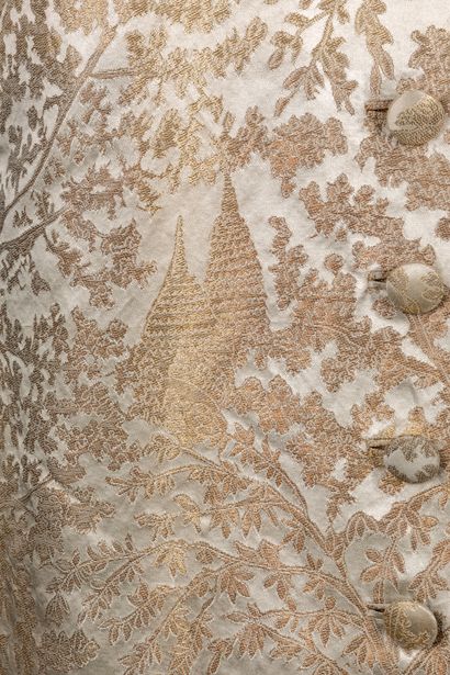 Maggy ROUFF 象牙色背景上的金色薄片晚装，带有印度尼西亚寺庙图案。领口的大吊带上衣，大的溢出式口袋和小的褶皱裙裾。
签名：
1947年左右