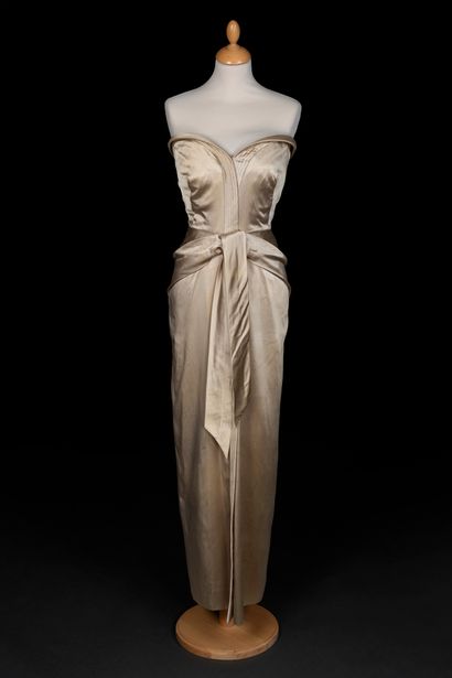 Jacques Griffe 公爵夫人缎面连衣裙，心形胸衣和相同款式的缎面蝴蝶结，夹在臀部，在前面落下
1950年左右