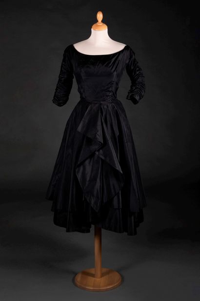 Cristobal BALENCIAGA 黑色塔夫绸连衣裙，大船领，聚拢的中长袖，环绕的下身，前面有交叉的褶皱
1961年春夏（腰带后面有一个小的蹂躏。）