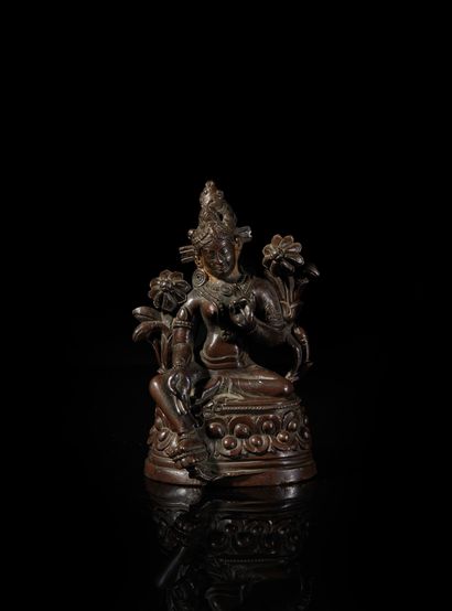 TIBET - XVIIIe/XIXe siècle Statuette of green Tara in bronze with brown patina, face...