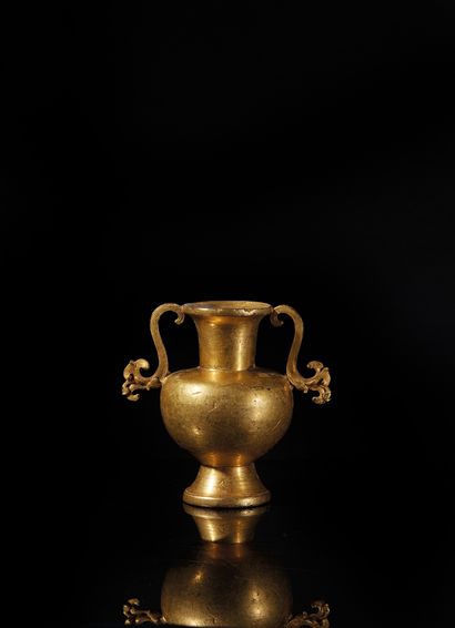 TIBET - XVIIIe siècle Vase rituel kalasha en bronze doré, à haut col évasé, les anses...