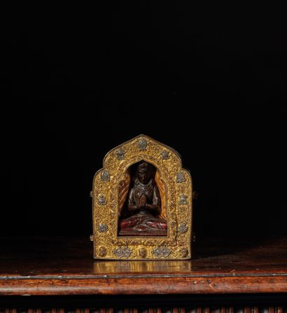 TIBET - XVIIe et XVIIIe siècle 鎏金铜和银金属制成的便携式ga'u祭坛，装饰着八个佛教符号（ashtamangala）和神灵的头像，以及交织在一起的环形图案，围着一尊部分多色的观音菩萨木雕，双手持宝，坐在莲花上的padmasana。（缺少两只手臂）
，木雕12厘米，ga'u...