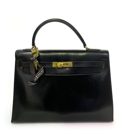 null Hermes Paris. Kelly model handbag in black leather with gold metal trim, lock...