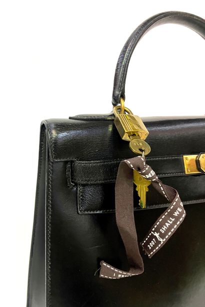 null Hermes Paris. Kelly model handbag in black leather with gold metal trim, lock...