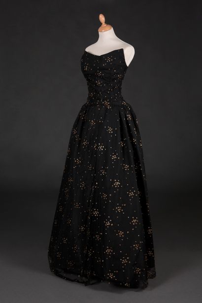 Cristobal BALENCIAGA Ball gown in black tulle applied with small gold sequins. Moon-shaped...