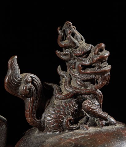 CHINE - XVIIIe siècle Brûle-parfum tripode à deux anses en bronze à patine brune...