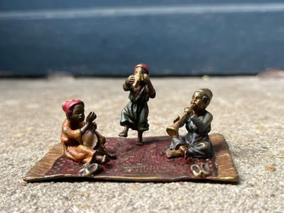 null Trois enfants musiciens sur un tapis
Bronze de Vienne polychrome (usures)
H....
