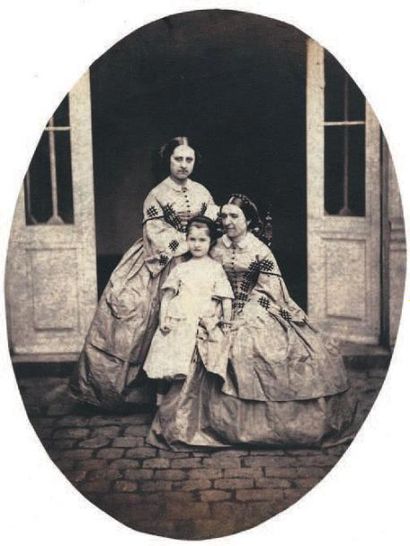 Auteur non identifié Portrait de deux femmes et fillette dans une cour pavée, c....