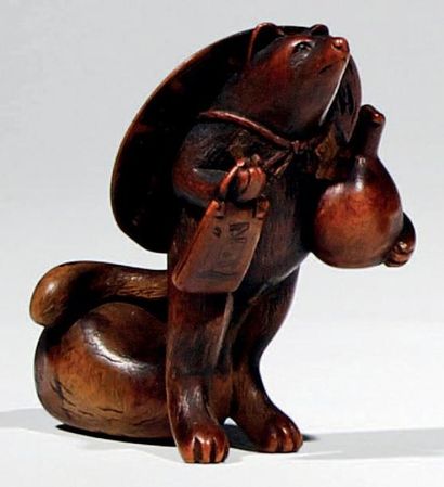 JAPON - Epoque EDO (1603 - 1868) Netsuke en buis, blaireau tanuki debout tenant une...