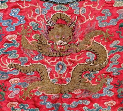 CHINE - Début XXe siècle Robe dragon de femme en soie rouge à décor brodé de dragons...