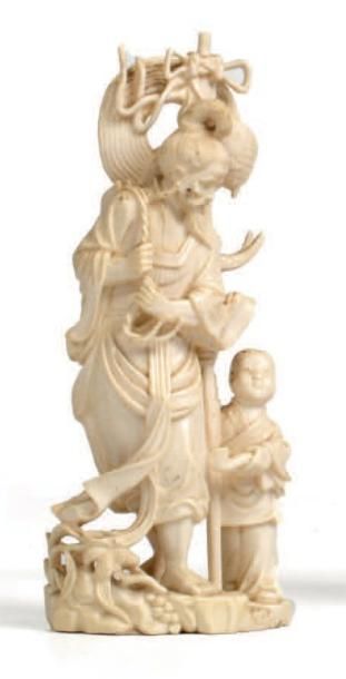 CHINE - Début XXe siècle Statuette en ivoire, vieillard debout avec un enfant. Hauteur:...