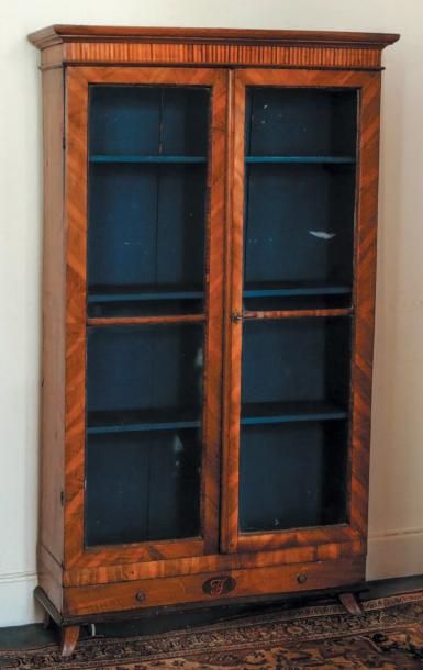 null Bibliothèque en bois de placage ouvrant par deux vantaux vitrés et par un tiroir,...
