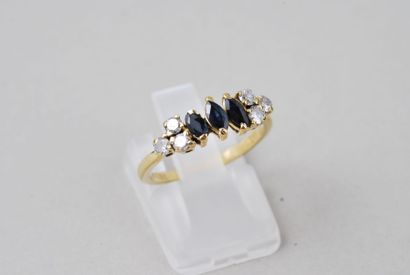 null Bague en or jaune 18K ornée de trois saphirs bleus taille navette, épaulés de...