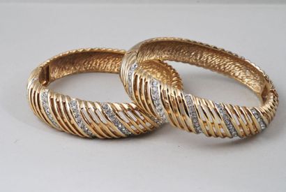null Paire de bracelets rigides ouvrants en métal doré, pavés de strass.