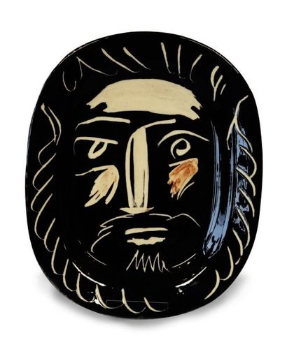 PICASSO (Editions MADOURA). Plat ovale en céramique à fond noir décoré d'une tête...